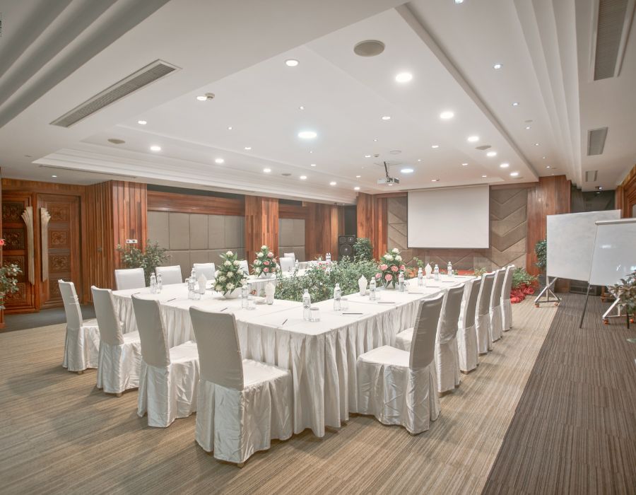 Spacious conference meeting room setup with white tables and chairs at J7 Hotel Siem Reap.