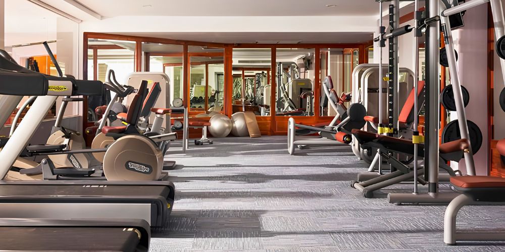 Focus on the prominent cardiovascular equipment in the foreground (treadmills, exercise bikes) while keeping your core local brand keywords solid.